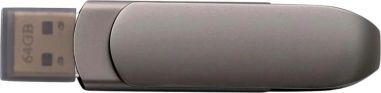Memoria USB de 64GB de aleación de zinc personalizada en grafito mate, apoyada junto a la caja metálica