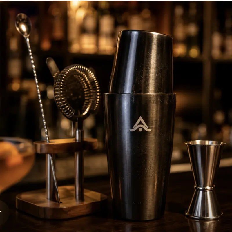 Coctelera personalizada con logo grabado, sobre la barra de un bar junto a otros accesorios de coctelería