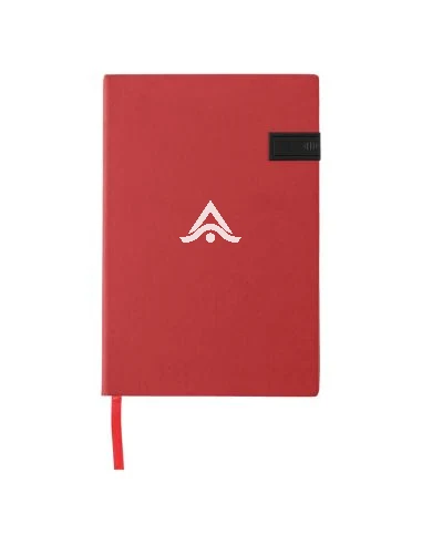 Cuaderno de notas personalizado con logo sobre una mesa de congreso, junto a un bolígrafo