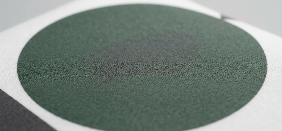 Macro de tinta verde serigrafiada sobre camiseta blanca de algodón